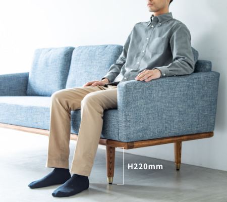 脚の高さ220mmに175cmの男性がソファFOLKEフォルケに座っている一例